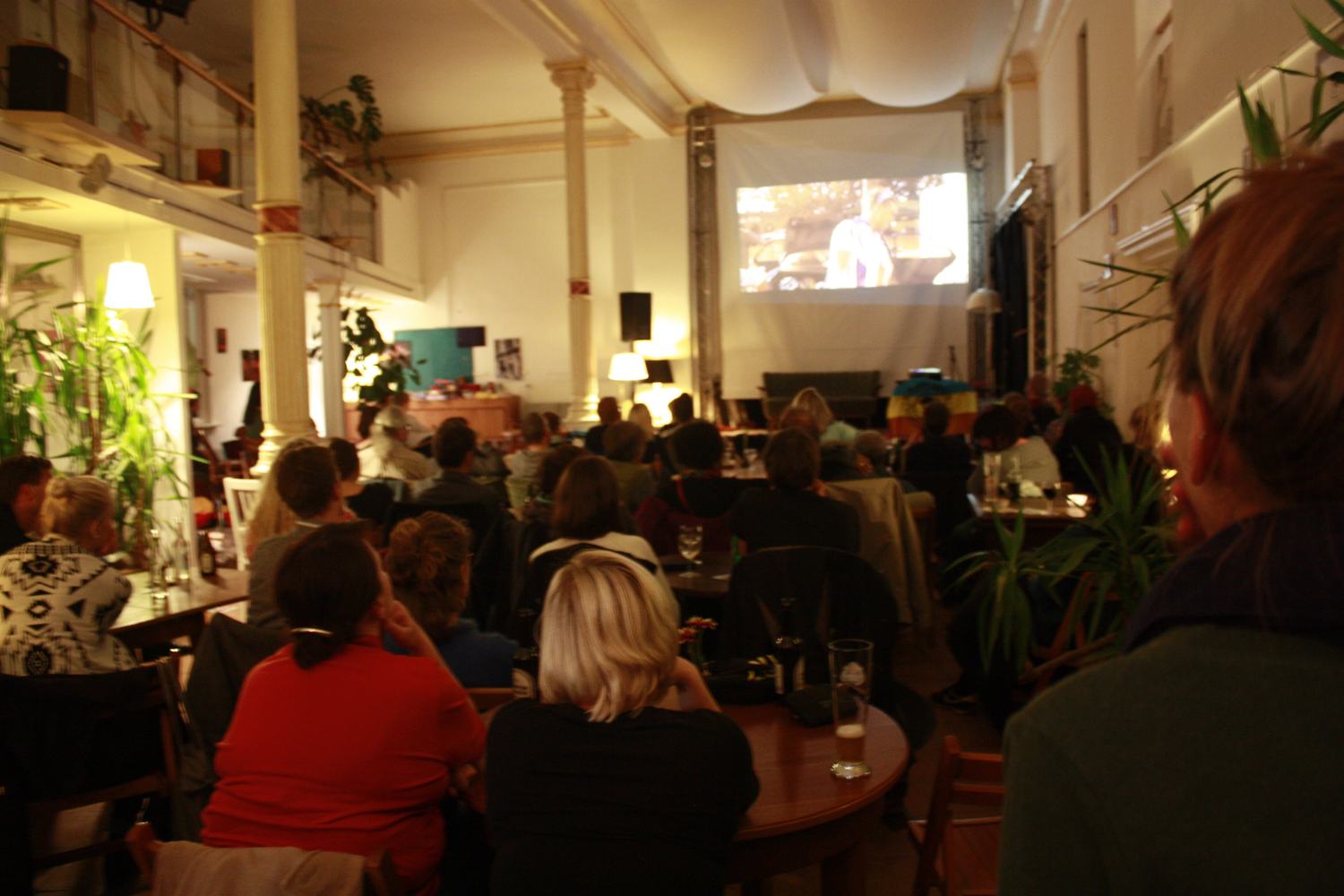 An audience watching a film in a small cinema room